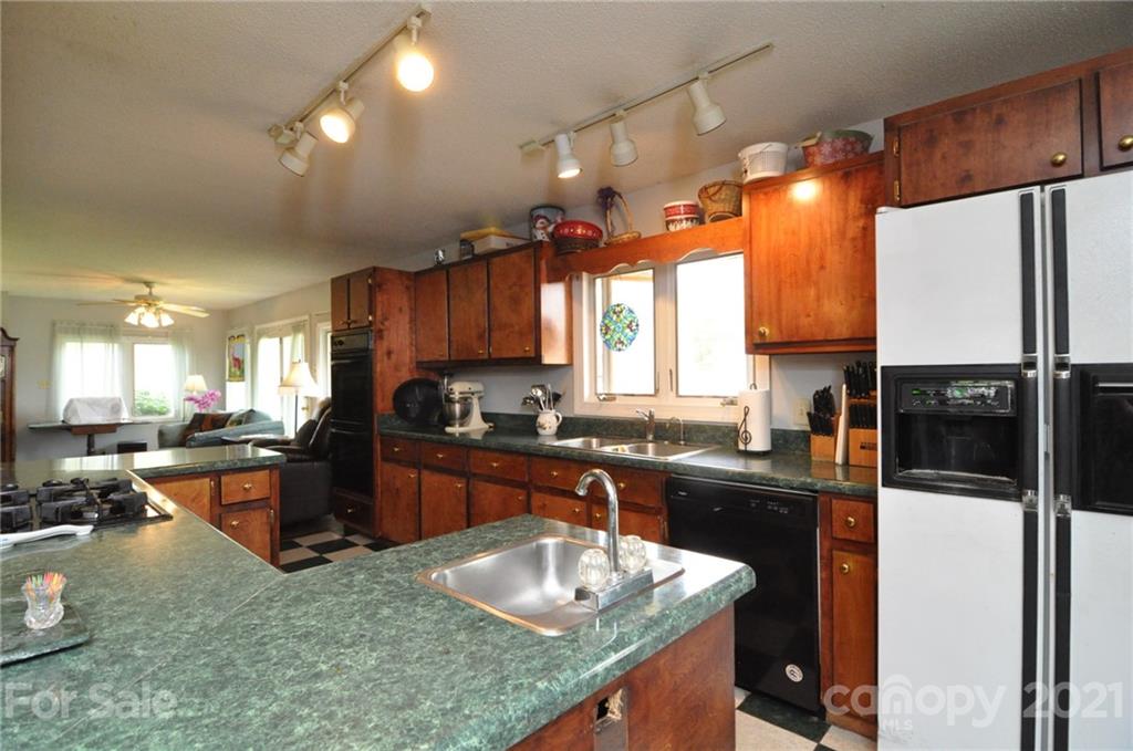 501 Redland Road Landrum, SC 29356 - Photo 14 of 38 a kitchen with granite countertop a sink stove and refrigerator