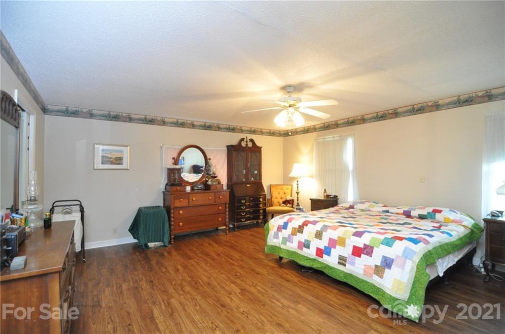 501 Redland Road Landrum, SC 29356 - Photo 23 of 38 a bedroom with a bed and a chandelier