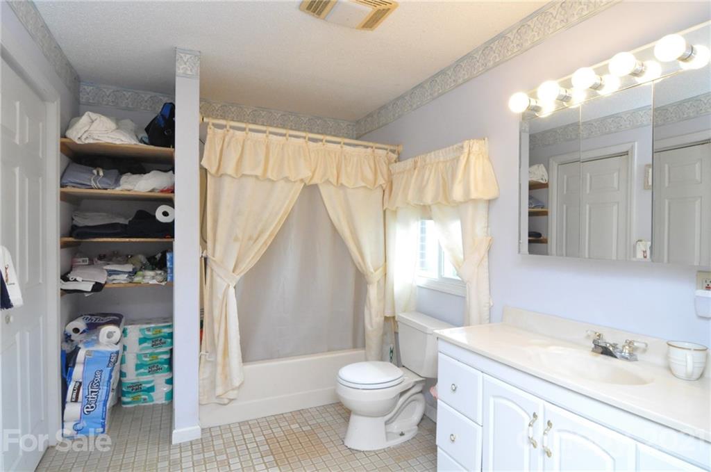 501 Redland Road Landrum, SC 29356 - Photo 25 of 38 a bathroom with a granite countertop sink a toilet and shower