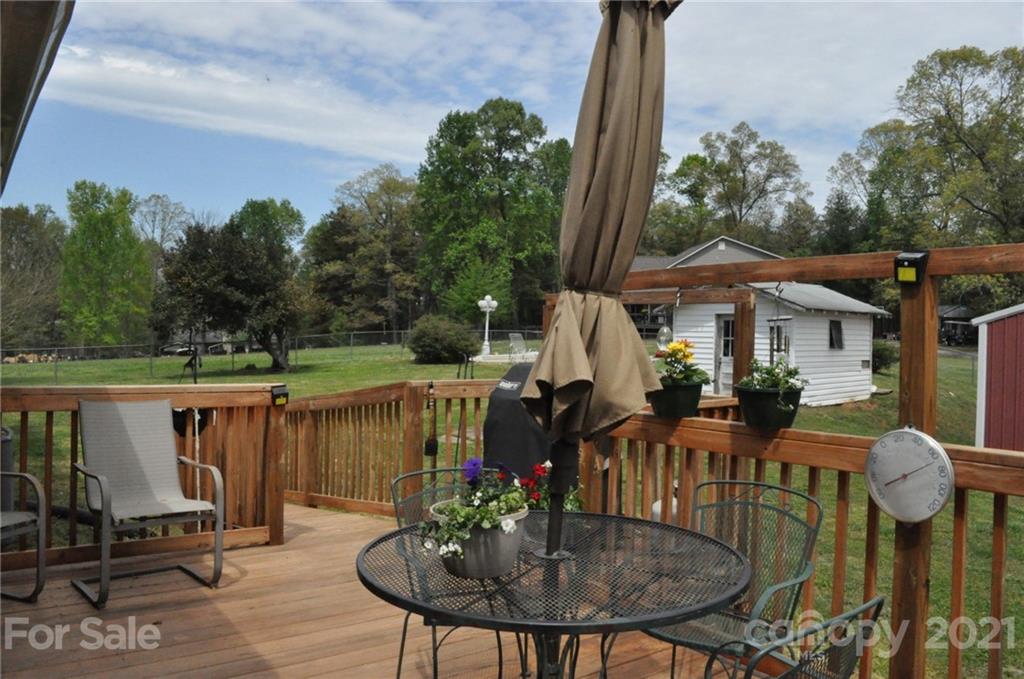 501 Redland Road Landrum, SC 29356 - Photo 7 of 38 a view of a patio with table and chairs potted plants with wooden floor