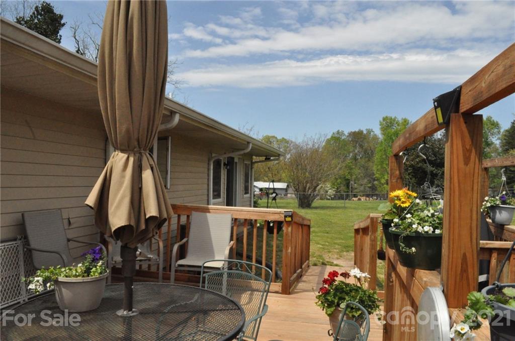 501 Redland Road Landrum, SC 29356 - Photo 8 of 38 a view of a patio with chairs potted plants and a floor to ceiling window