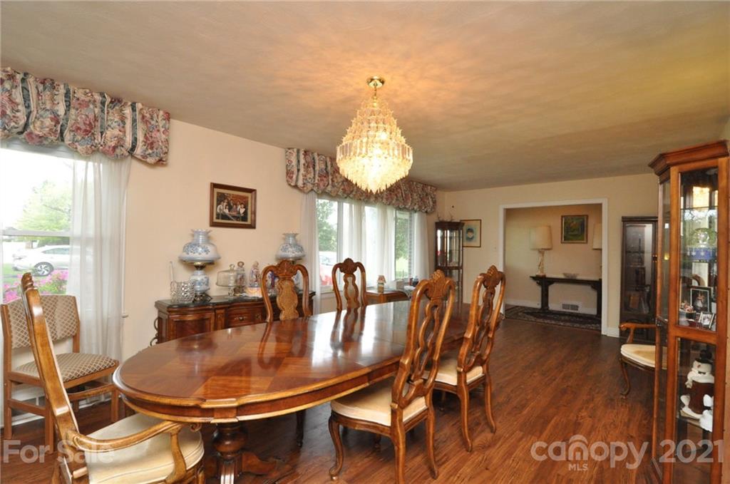 501 Redland Road Landrum, SC 29356 - Photo 10 of 38 a dining room with furniture a chandelier and wooden floor