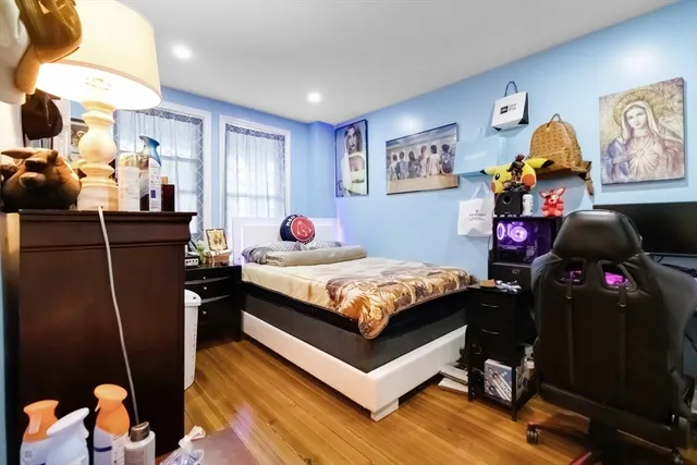 a bedroom with a bed and wooden floor