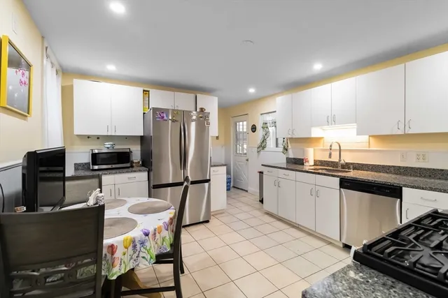 a kitchen with granite countertop a refrigerator stove top oven and sink