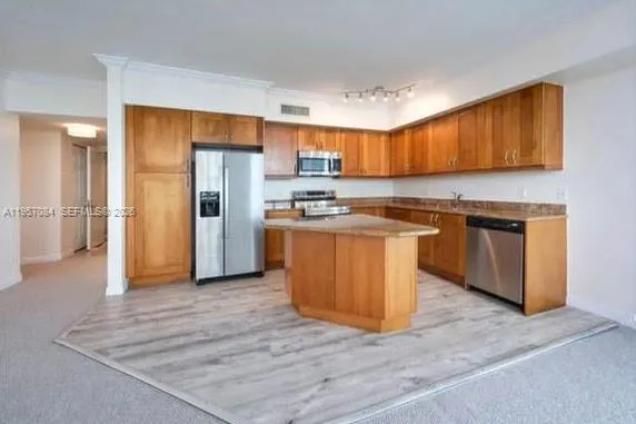 a kitchen with stainless steel appliances granite countertop a stove top oven a refrigerator and a sink with granite countertops