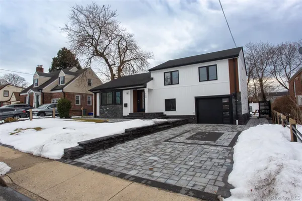 a front view of a house with a yard covered with snow in front of house