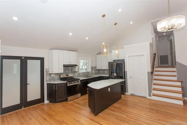 a kitchen with stainless steel appliances granite countertop a sink stove and refrigerator