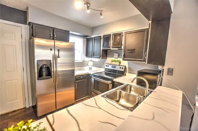 a kitchen with stainless steel appliances granite countertop a refrigerator and a stove
