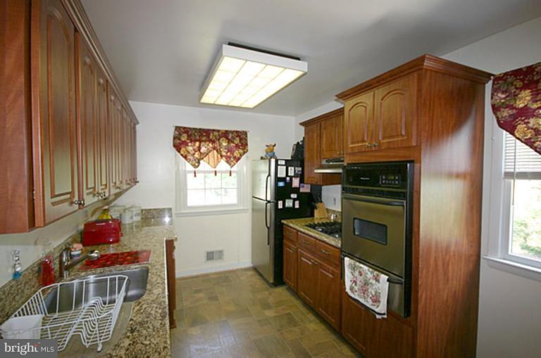 497 St Barbara Lane Odenton, MD 21113 - Photo 3 of 25 a kitchen with stainless steel appliances kitchen island granite countertop a refrigerator and a stove top oven
