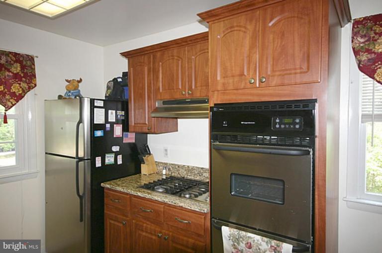 497 St Barbara Lane Odenton, MD 21113 - Photo 5 of 25 a kitchen with stainless steel appliances granite countertop a stove a refrigerator and a microwave