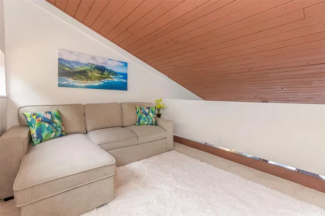 a living room with couches and painted wall with a potted plant