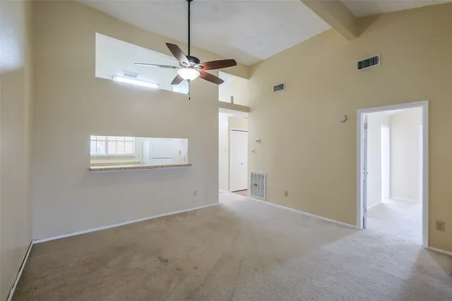 a view of a big room with a ceiling fan and a window
