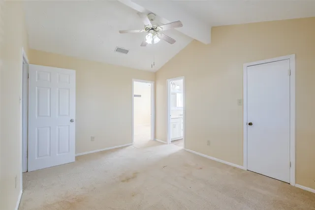 a view of a room with a ceiling fan and a window