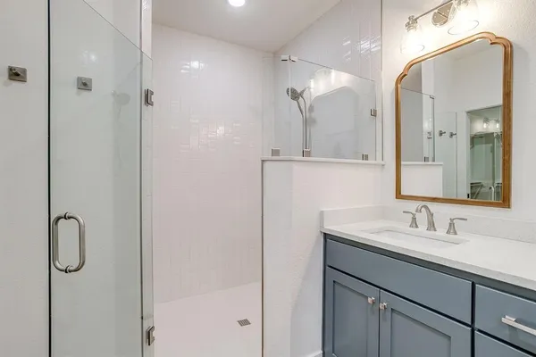 a bathroom with a shower sink and mirror