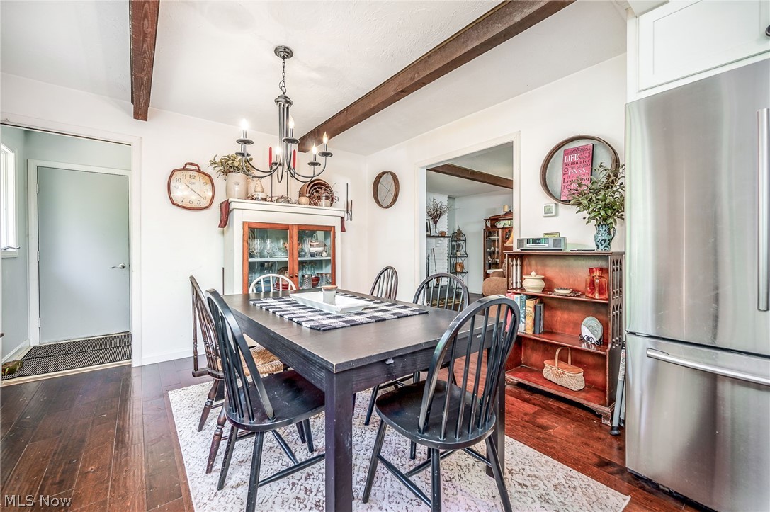 2369 Allen Road Austinburg, OH 44010 - Photo 11 of 32 Dining area with dark wood-type flooring, beamed ceiling, and an inviting chandelier