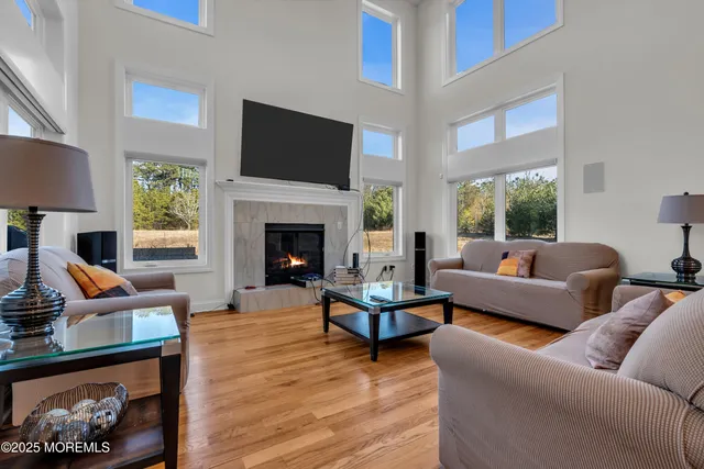 a kitchen with stainless steel appliances granite countertop a refrigerator a sink dishwasher a stove and a dining table with wooden floor