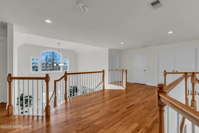 a bedroom with a bed lamp and paintings on the wall