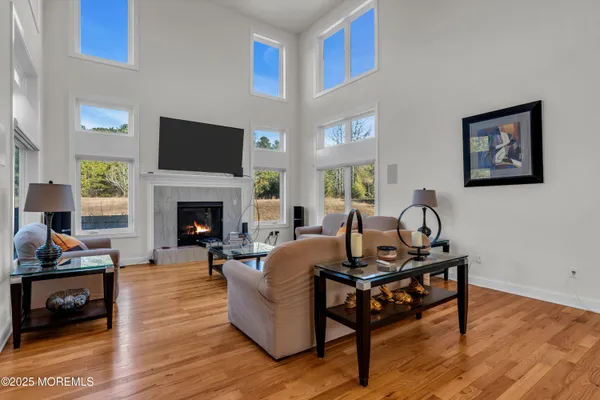 a kitchen with stainless steel appliances granite countertop a refrigerator a sink dishwasher a dining table and chairs with wooden floor