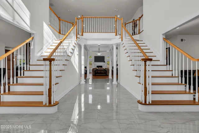 a view of staircase with lots of frames on wall and windows