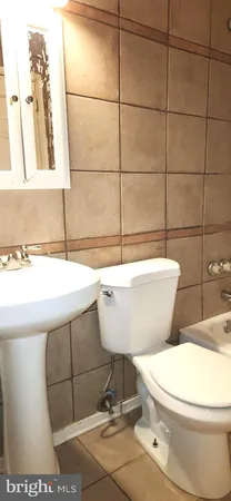 a bathroom with a toilet a sink and mirror