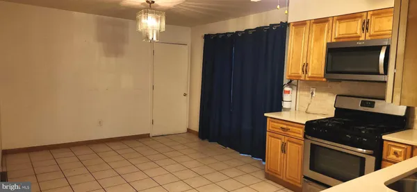a kitchen with a refrigerator and a stove top oven