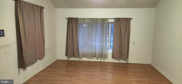an empty room with wooden floor and a window