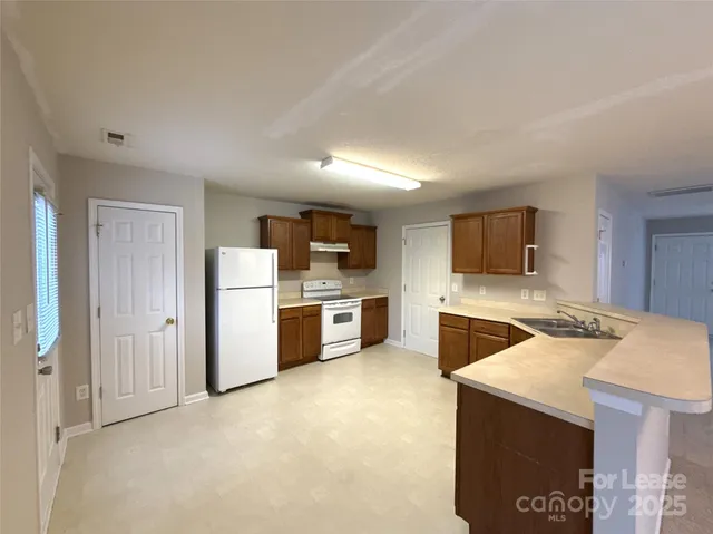 a kitchen that has a lot of cabinets and wooden floor