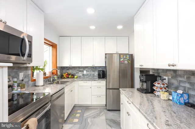 a kitchen with a sink a refrigerator and a stove top oven