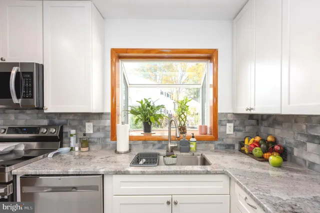 a kitchen with a window a sink and cabinets