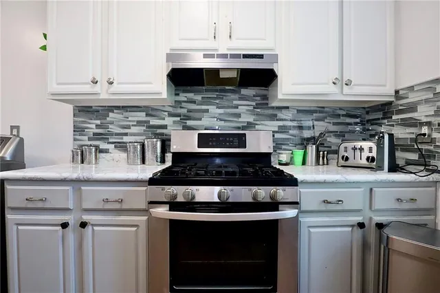 a stove top oven sitting inside of a kitchen