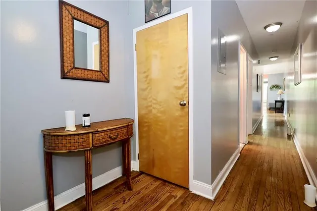 a view of a hallway with wooden floor and staircase