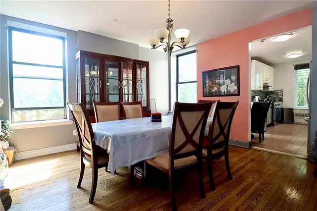 a view of a dining room with furniture a chandelier and wooden floor