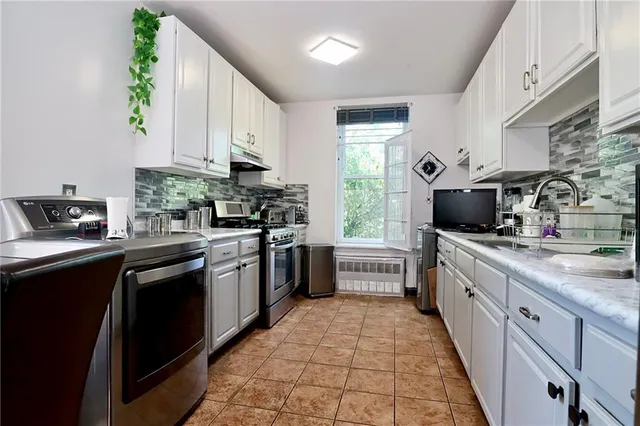a large kitchen with a stove top oven a sink a microwave and dining table