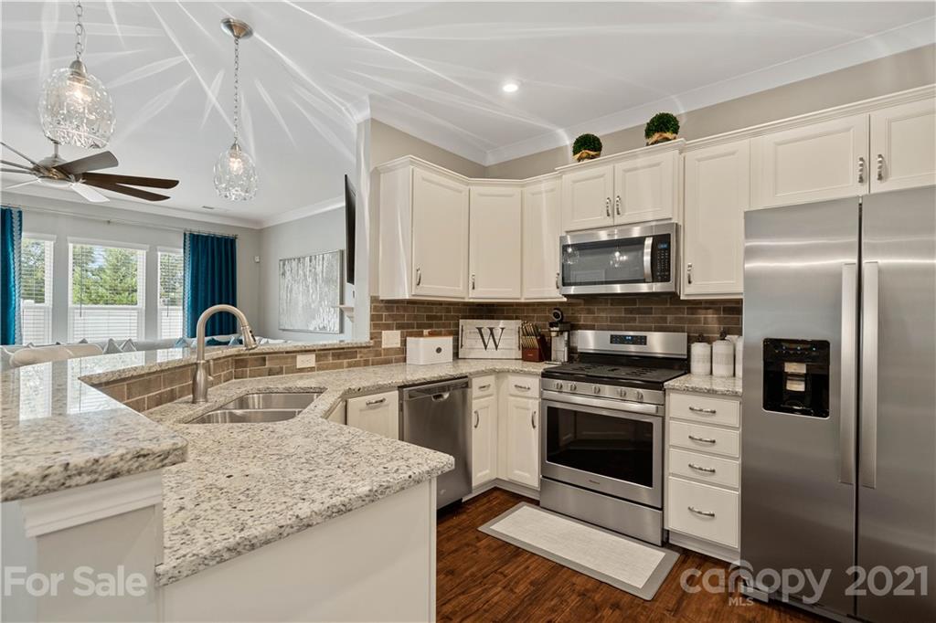 921 Wicawa Road, Unit 309 Fort Mill, SC 29708 - Photo 8 of 28 a kitchen with stainless steel appliances granite countertop a sink a stove a refrigerator cabinets and a counter top space