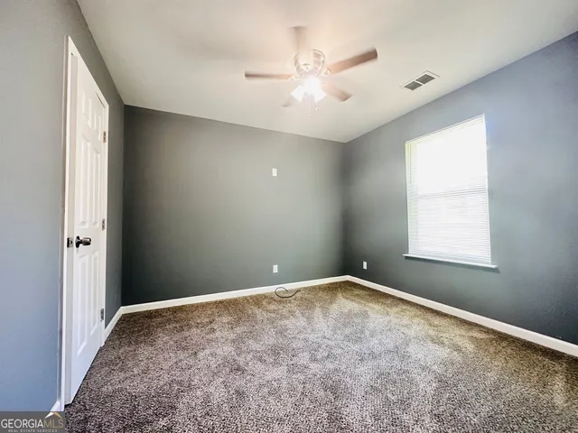 an empty room with a chandelier fan