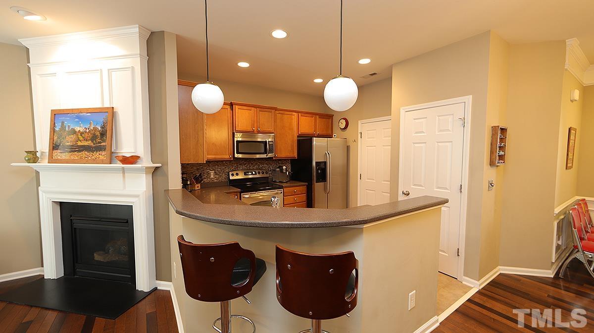 7020 Racine Way Raleigh, NC 27690 - Photo 25 of 26 a kitchen with stainless steel appliances a stove a sink and a fireplace