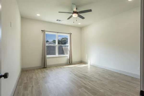 an empty room with fan and entrance