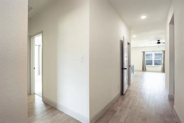 a view of a hallway with wooden floor