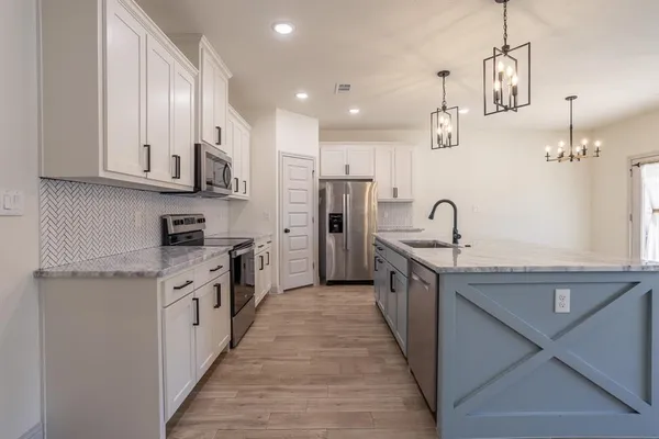 a kitchen with kitchen island granite countertop stainless steel appliances cabinets a sink and a counter top space