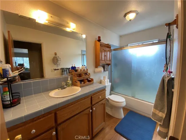 a bathroom with a sink a toilet a mirror and shower