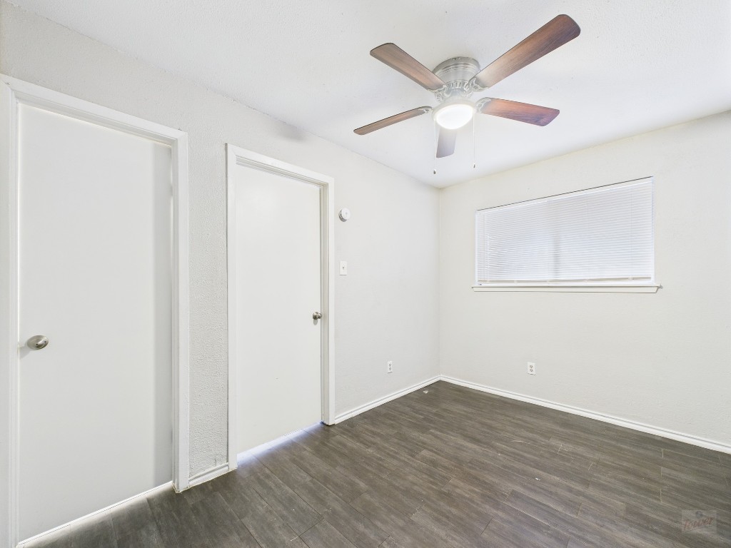 1840 Burton Drive, Unit 141 Austin, TX 78741 - Photo 19 of 24 an empty room with wooden floor and ceiling fan
