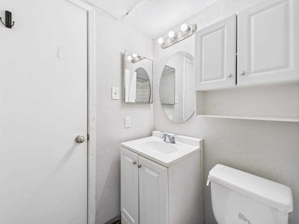 1840 Burton Drive, Unit 141 Austin, TX 78741 - Photo 24 of 24 a bathroom with a toilet a sink and mirror