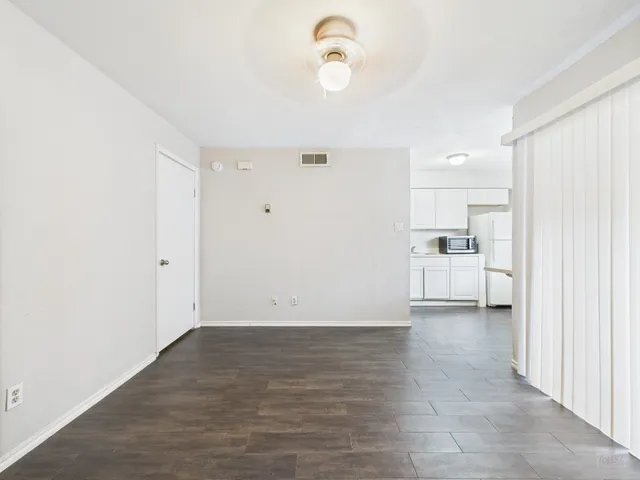 a view of a kitchen with wooden floor and a refrigerator