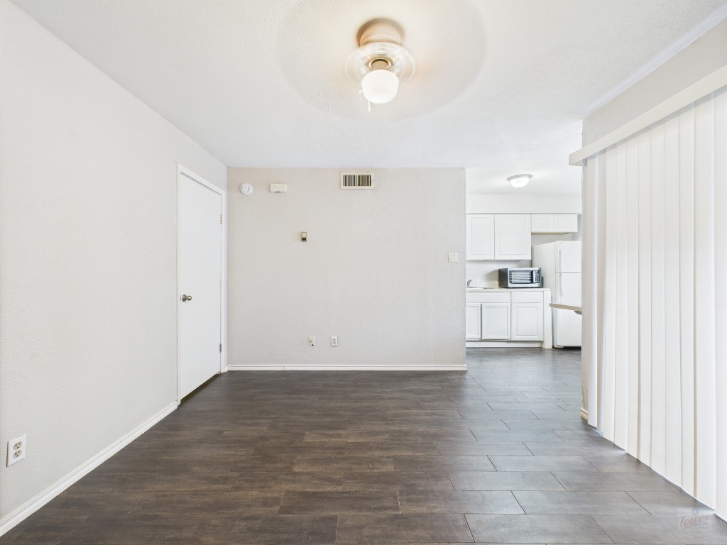 1840 Burton Drive, Unit 141 Austin, TX 78741 - Photo 3 of 24 a view of a kitchen with wooden floor and a refrigerator