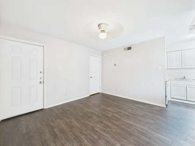 a view of a kitchen with wooden floor and a window