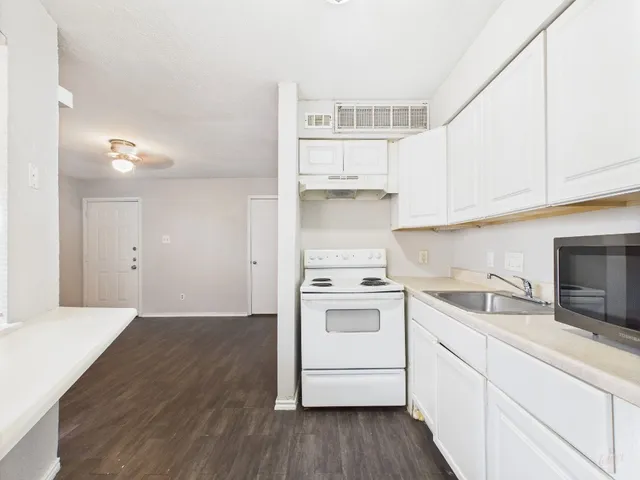 a kitchen with a sink a stove and cabinets