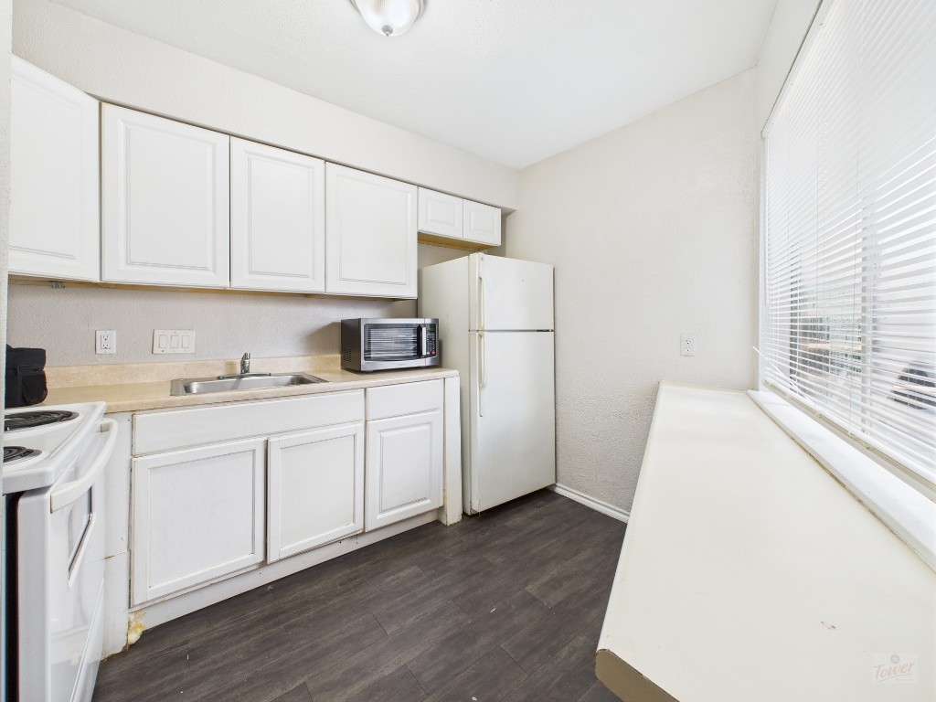 1840 Burton Drive, Unit 141 Austin, TX 78741 - Photo 10 of 24 a kitchen with sink a refrigerator and white cabinets
