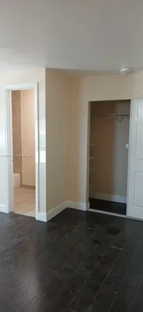 an empty room with wooden floor and closet