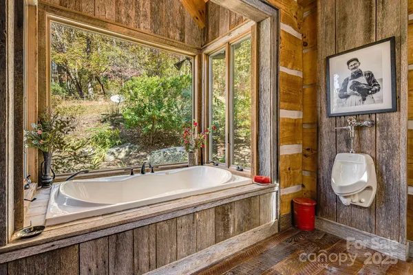 a bathroom with a tub a sink and a window