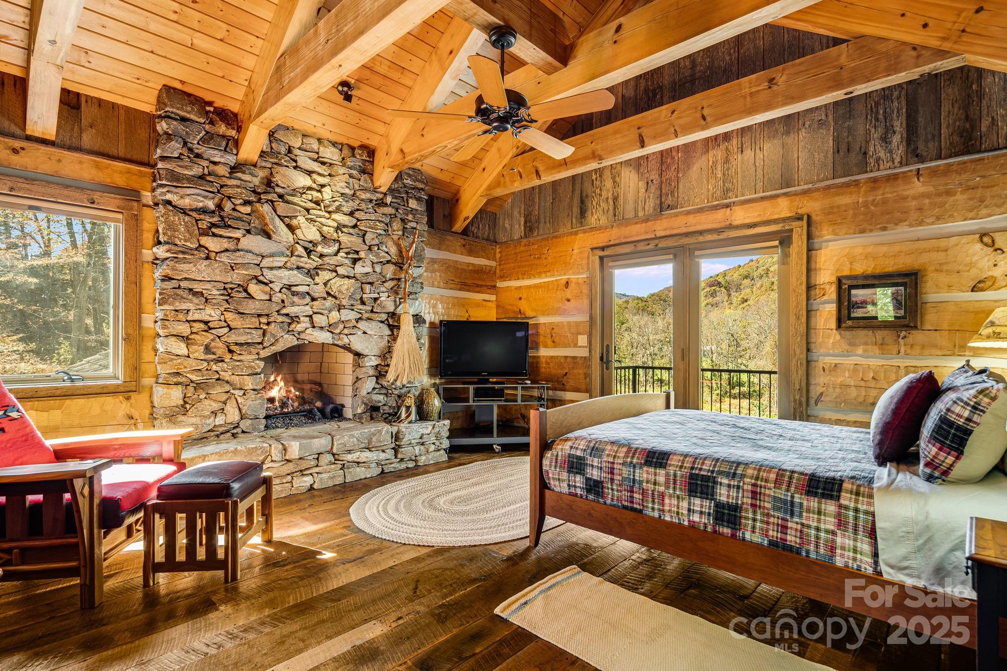 99 Thistle Ridge Canton, NC 28716 - Photo 28 of 48 a view of a patio with couches table and chairs under an umbrella with a fireplace